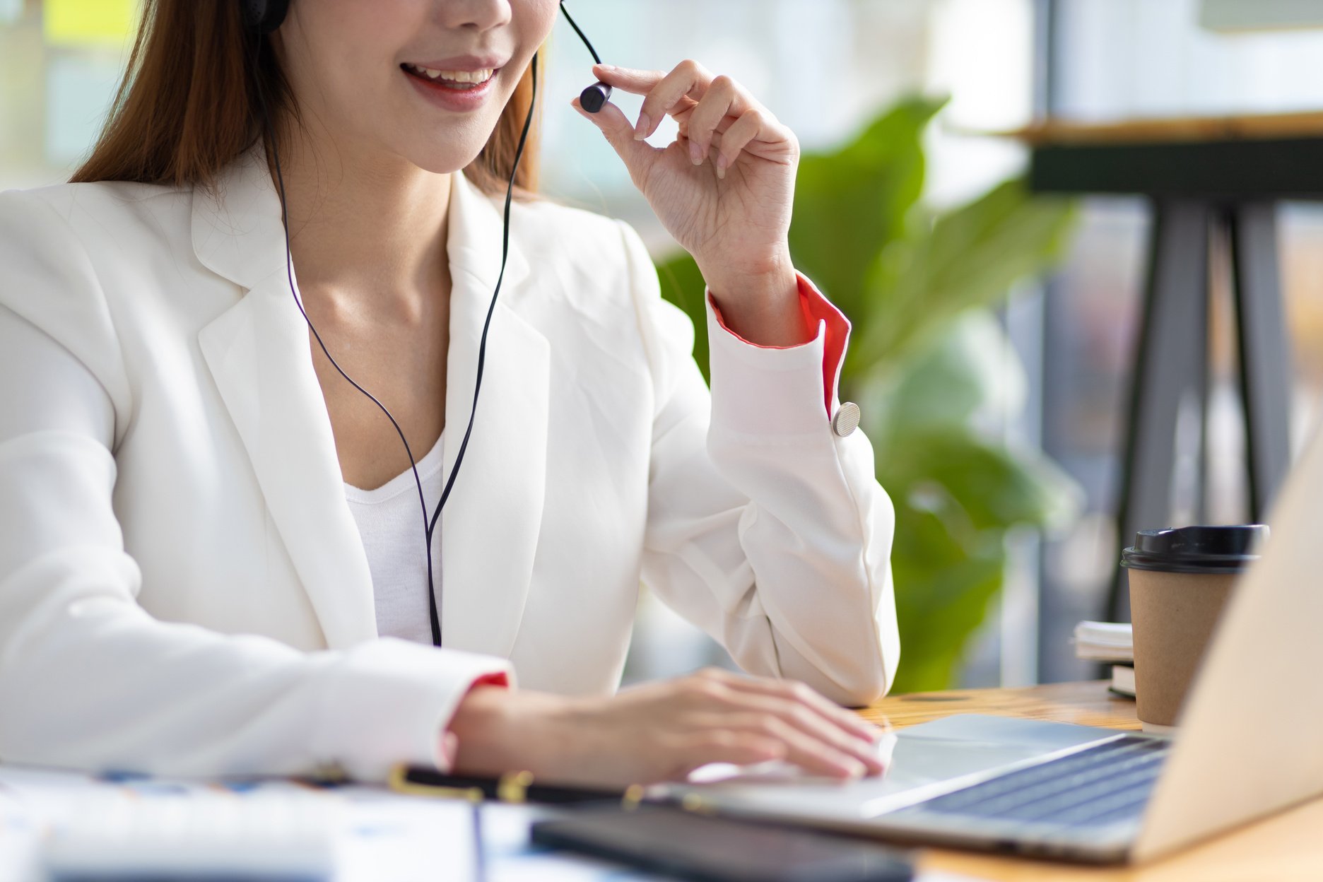 Telephone operator or customer service representative working in a call center office.